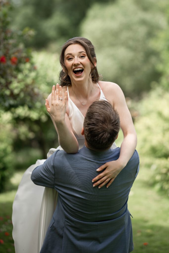 Braut lacht und zeigt ihren Ehering beim Hochzeitsshooting im Hofgut Hohenstein
