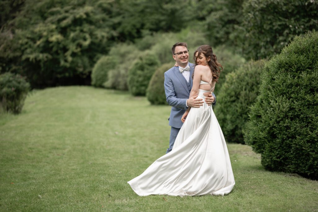 Bräutigam umarmt die Braut von hinten beim Paarshooting im Hofgut Hohenstein