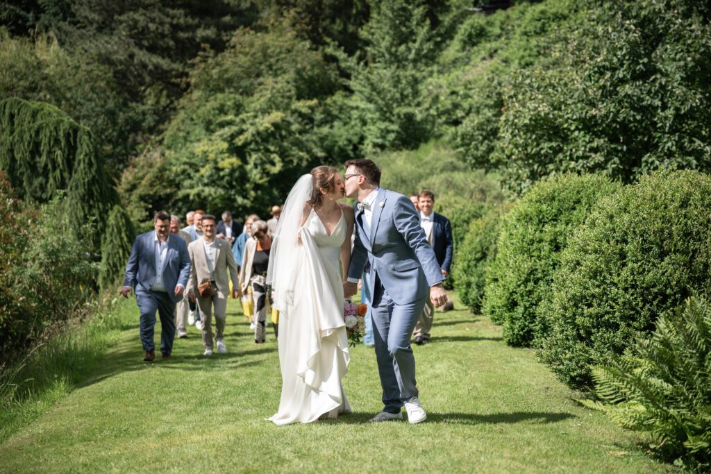 Braut und Bräutigam küssen sich nach der Trauung im Hofgut Hohenstein