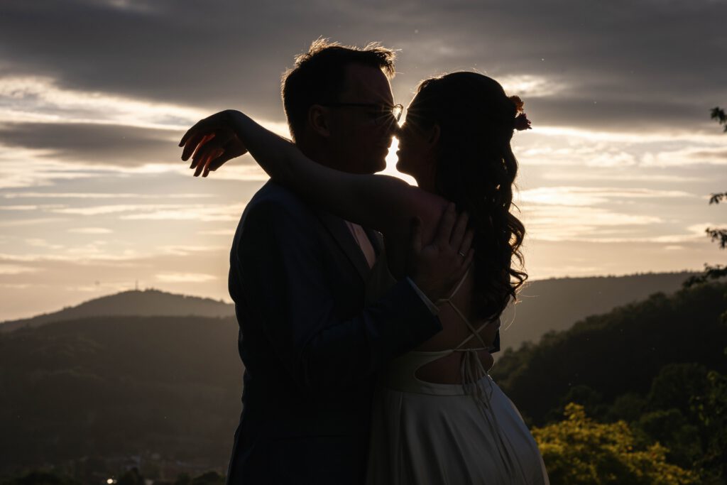 Silhouette von Braut und Bräutigam beim Kuss im Sonnenuntergang im Hofgut Hohenstein