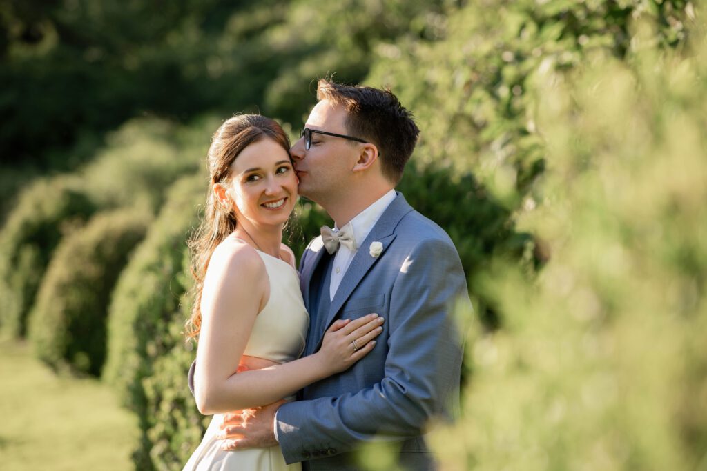 Bräutigam küsst die Braut auf die Wange beim Hochzeitsshooting im Hofgut Hohenstein