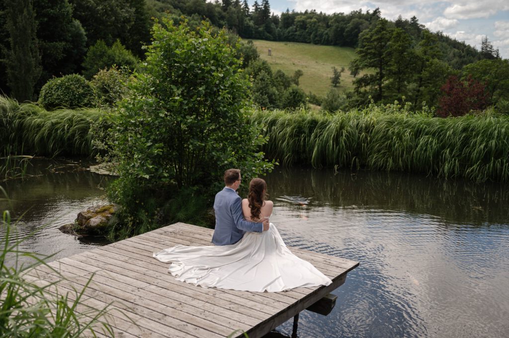 Brautpaar am Steg mit Blick über den Teich im Hofgut Hohenstein