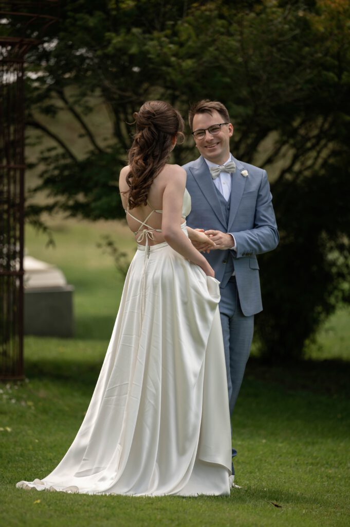 Braut und Bräutigam lachen und halten sich an den Händen im Hofgut Hohenstein