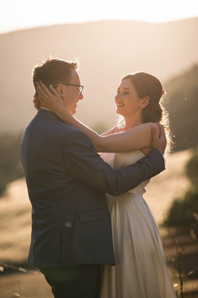 Braut und Bräutigam umarmen sich im Gegenlicht bei Sonnenuntergang im Hofgut Hohenstein